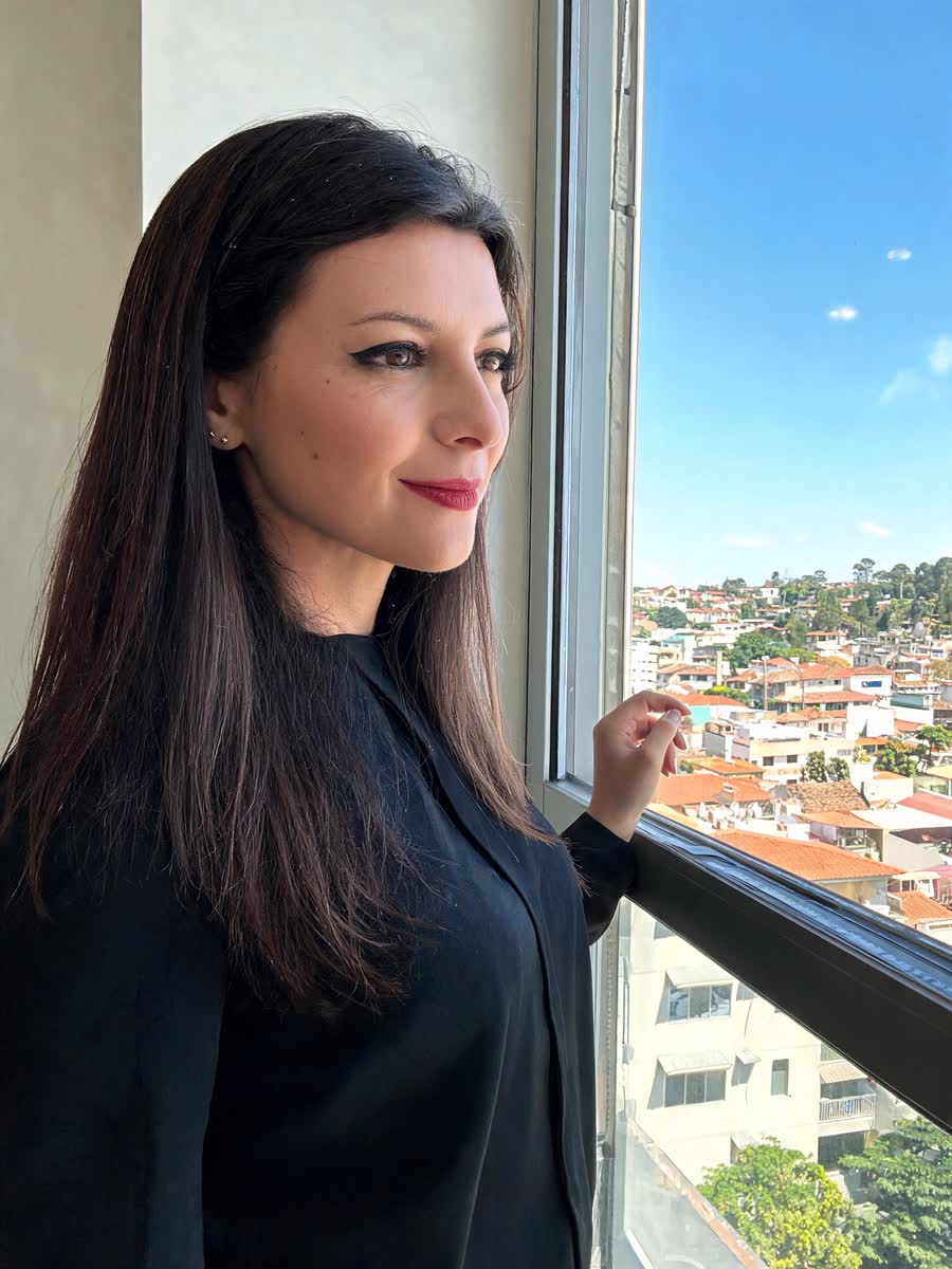 Inara Rezende de Oliveira, psicóloga infantojuvenil, junto à janela do consultório olhando para Jataí